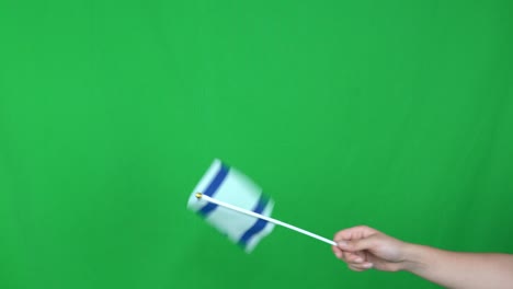 close up of unknown hand holding a waving israel flag on green screen background