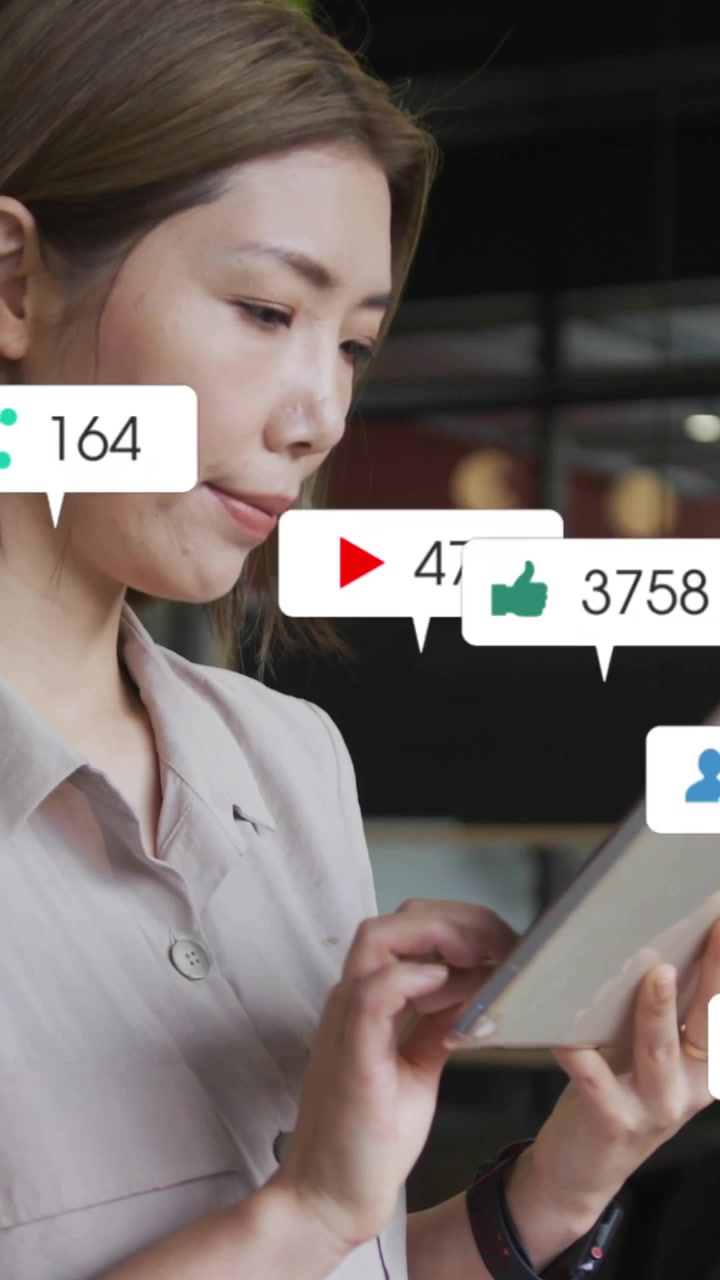 Vertical video: Woman tapping tablet in cafe causing alerts rising around tablet into social likes