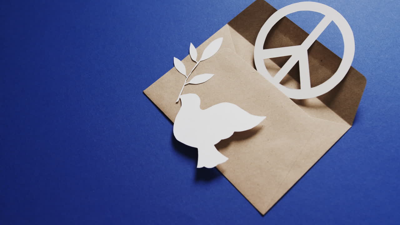 잎,  ⁇ 색 평화 표지, 봉투 및 파란색 배경에 복사 공간과 함께  ⁇  비둘기의 클로즈업