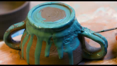 hand of artist painting earthenware bowl