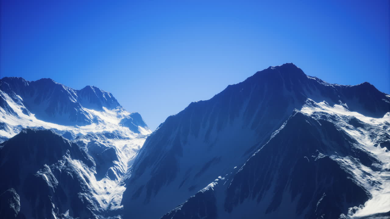 Majestic snow capped peaks reflecting the vivid blue sky in daylight