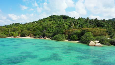 blue turquoise lagoon washing private exotic beach hidden by lush vegetation and big limestone cliffs on shoreline of tropical island in thailand