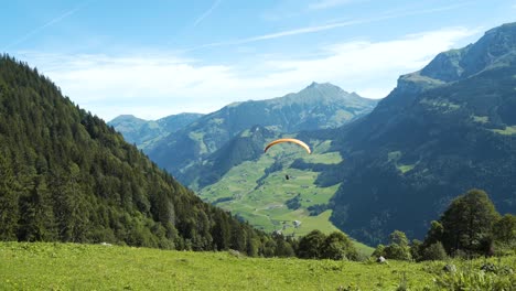 Paraglider-flying-down-the-mountain-in-the-Swiss-Alps