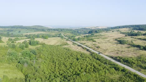 Car-Driving-On-The-Road-To-Prohodna-Cave-Along-Green-Landscape-In-Summer-In-Bulgaria