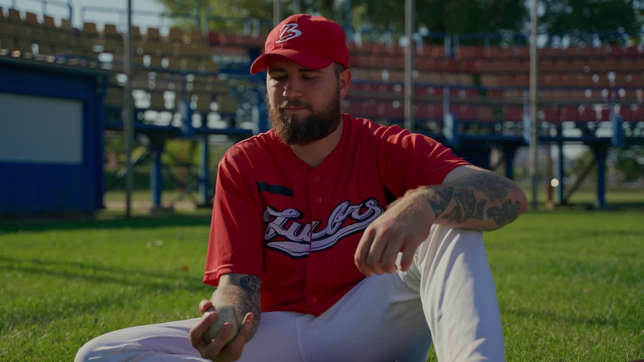 Jogador de beisebol sentado em campo de grama