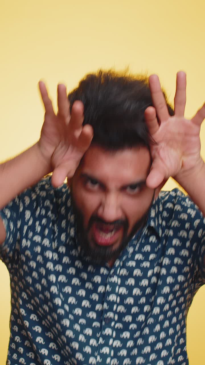 Uomo indiano comico e divertente che fa espressioni facciali sciocche giocose che scherza mostrando la lingua
