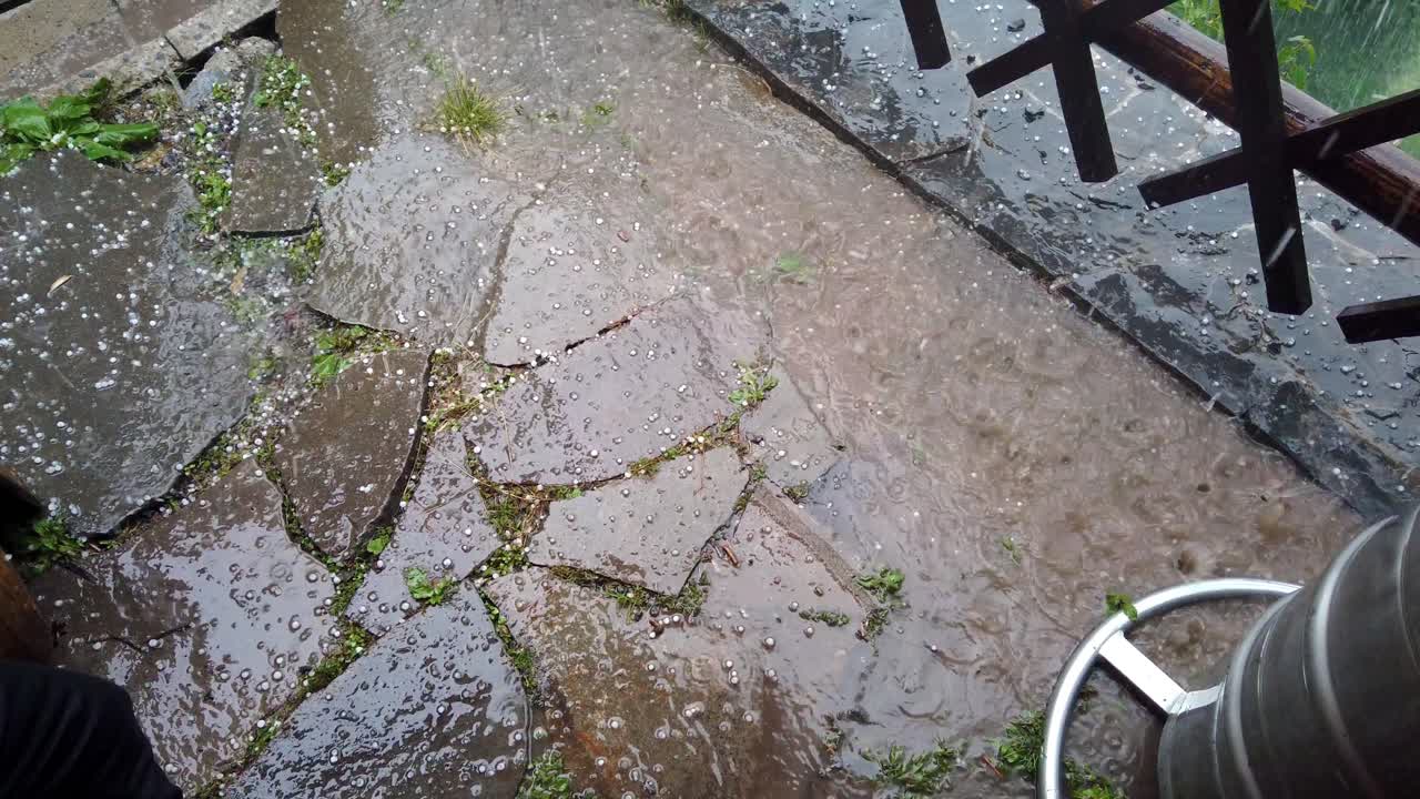 granizo cayendo en primer plano y en charco, cámara lenta