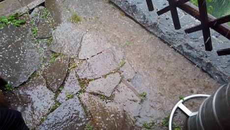 hail falling on foreground and into puddle, slow motion