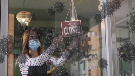 animation of coronavirus cells over caucasian female hairdresser wearing face mask