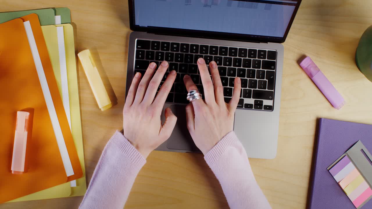 Person Typing on Laptop at Desk with Documents