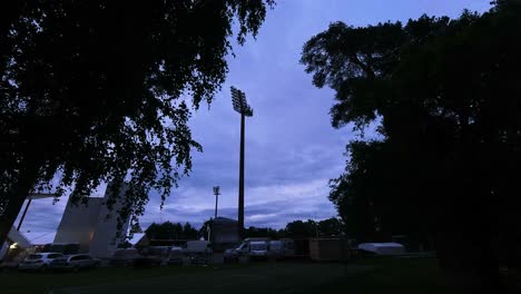 Lapso-De-Tiempo-De-Un-Estacionamiento-Con-Nubes-Rodando-En-El-Cielo-De-Tarde-A-Noche