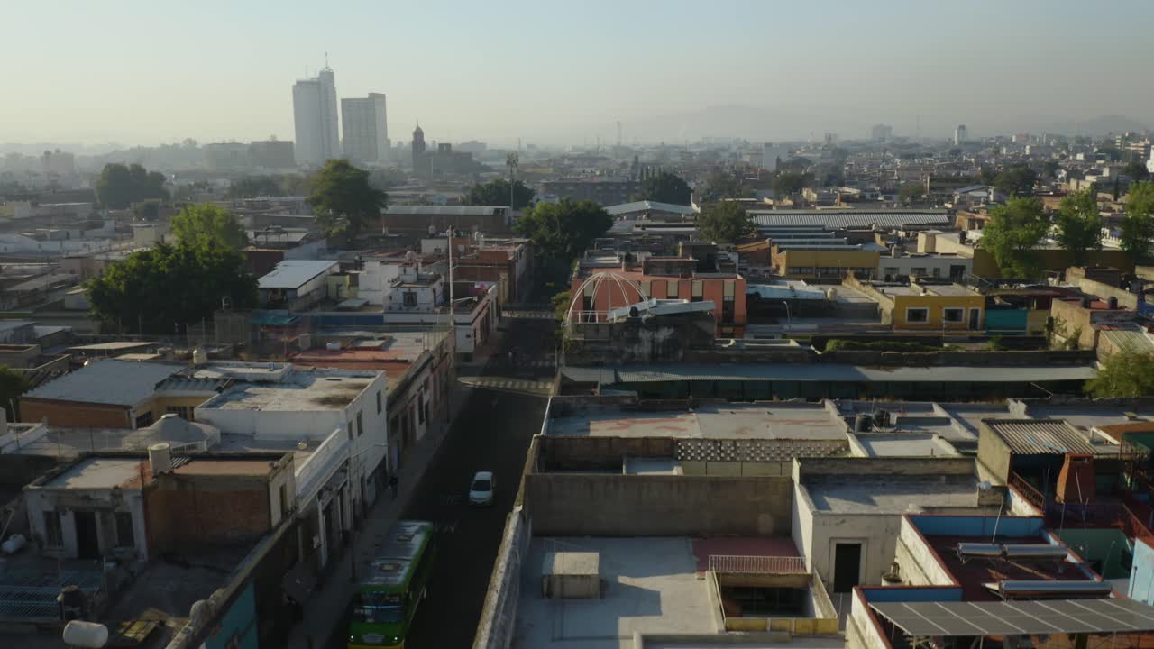 드론이 멕시코 과달라하라에서 흐릿한 아침에 내려오면서 거리를 달리는 버스와 자동차