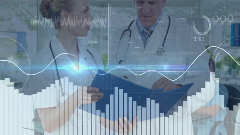 female doctor pointing folder in clinic, male doctor reviewing data showing digital graphs