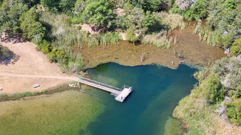 Panorámica-Hacia-Un-Muelle-De-Pesca-En-Una-Pequeña-Ensenada-En-Un-Lago