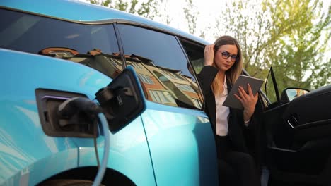 business on the go, charging an electric car and working on a laptop