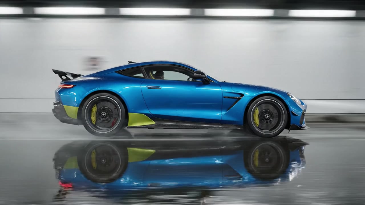 Auto sportiva blu dinamica ed elegante che sfreccia attraverso un ambiente moderno con riflessi sulla superficie bagnata, catturata in due fotogrammi di movimento.