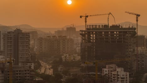 tiempo de puesta de sol detrás de las montañas y el paisaje urbano vista, desarrollo y crecimiento de los edificios altos en la ciudad