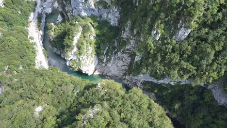 Majestic-river-in-deep-rocky-canyon,-aerial-drone-view