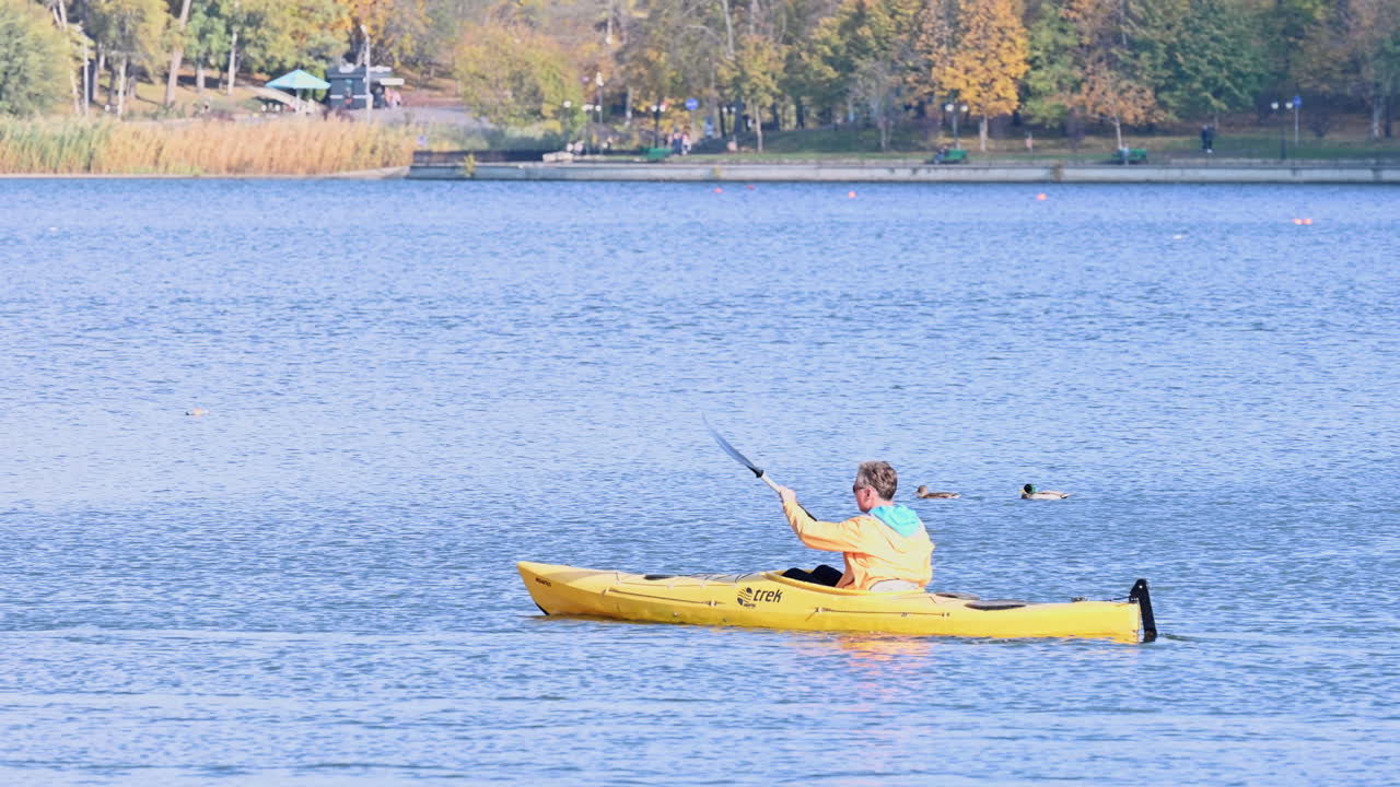 Chisinau, Moldova - October 13, 2022: Man kayaking on a lake in a park