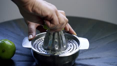 Nice-shot-of-woman-juicing-a-lime-using-a-traditional-steel-juicer-lemon-lime-citrus-vitamin-c