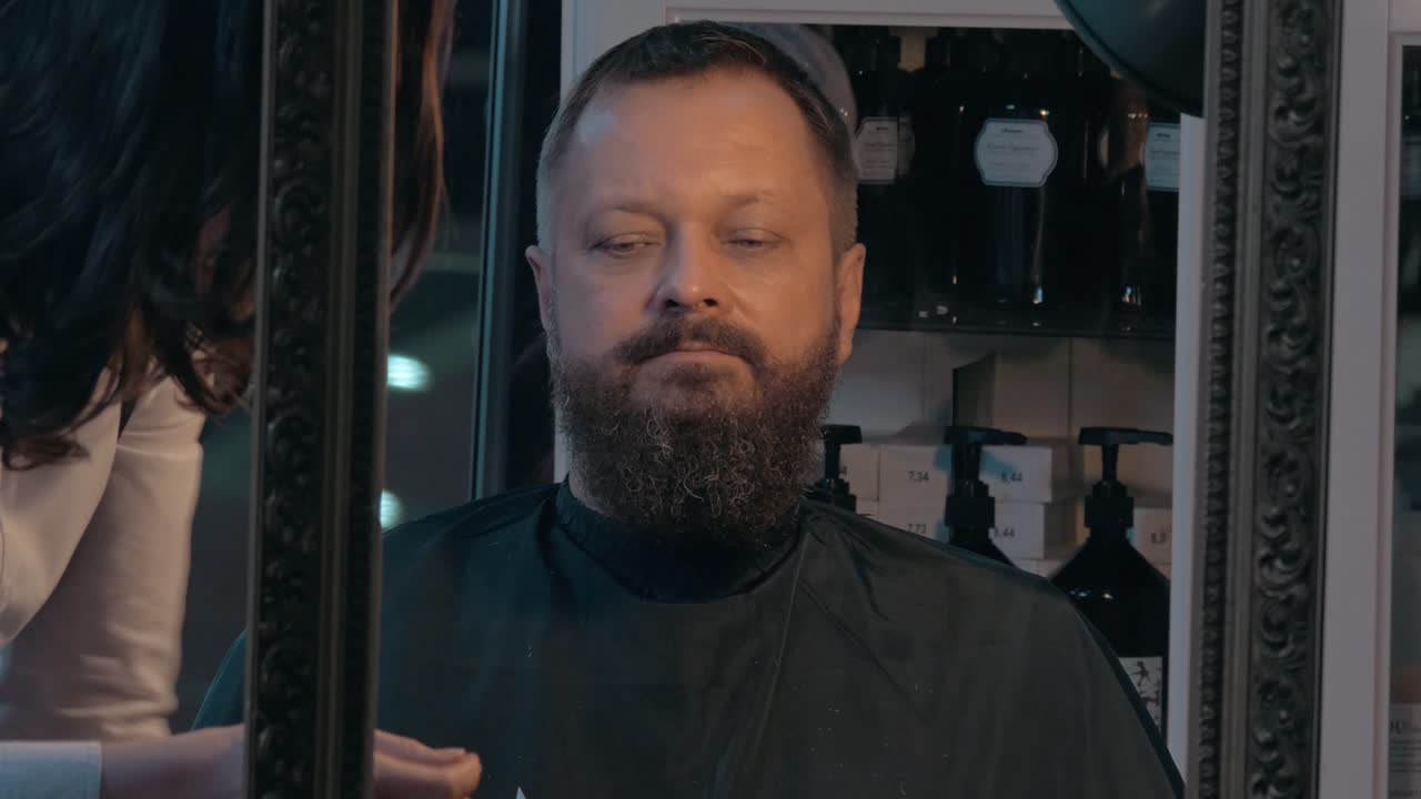 el barbero está terminando de cortar la barba.