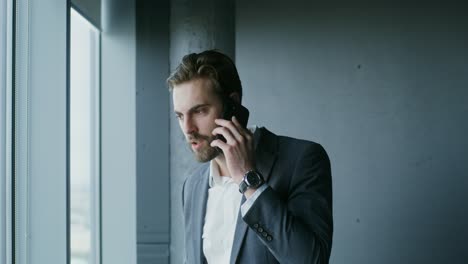 businessman on phone by window