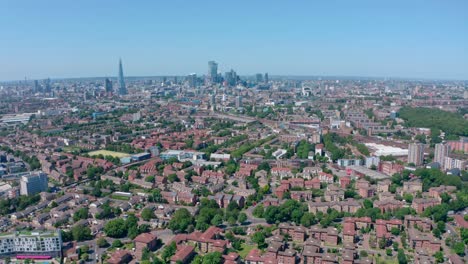dolly back drone shot of city of london skyscrapers from residential southwark