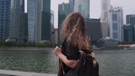 woman with backpack looking at city view