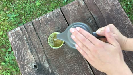 a person pours tea in a cup