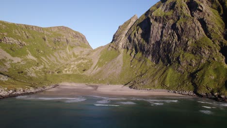 Toma-De-Retroceso-De-Magníficas-Montañas-Verdes-En-La-Playa-De-Kvalvika,-Noruega