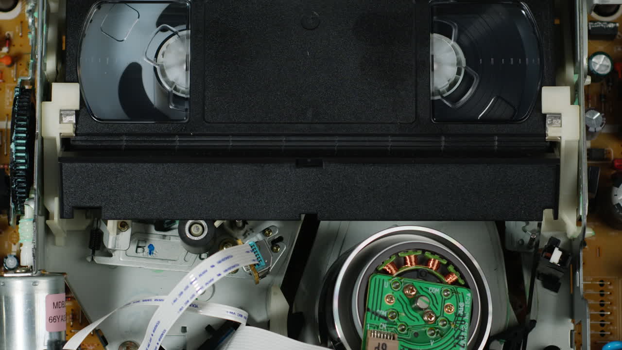 Old video recorder inside close-up, VHS. Retro player in neon blue light, vintage video cassette broadcasting, audio tape.