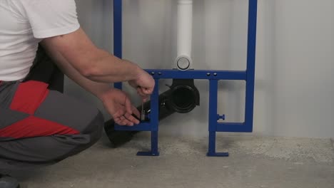 the worker who repairs and installs the toilet bowl and flush uses tools such as pliers and spanners