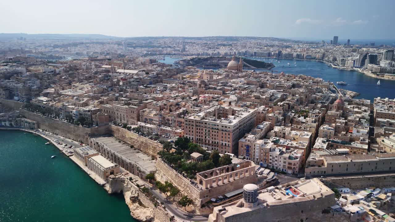 Aerial view of coastal city with historic buildings and vibrant sea