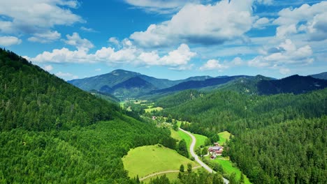 Aerial-footage-of-a-picturesque-mountain-valley-surrounded-by-lush-green-forests-and-a-serene-rural-landscape-on-sunny-day-in-Austria