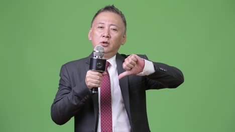 마이크를 사용하는 성숙한 일본 사업가