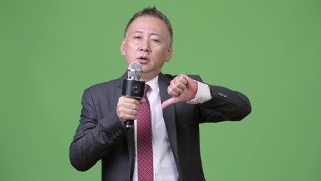 mature japanese businessman using microphone