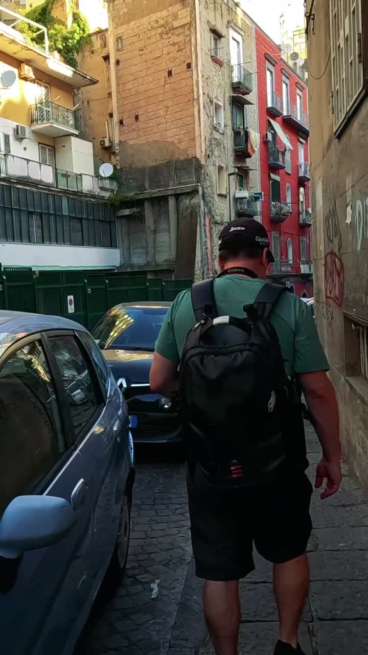 hombre navegando por un callejón estrecho con coches estacionados