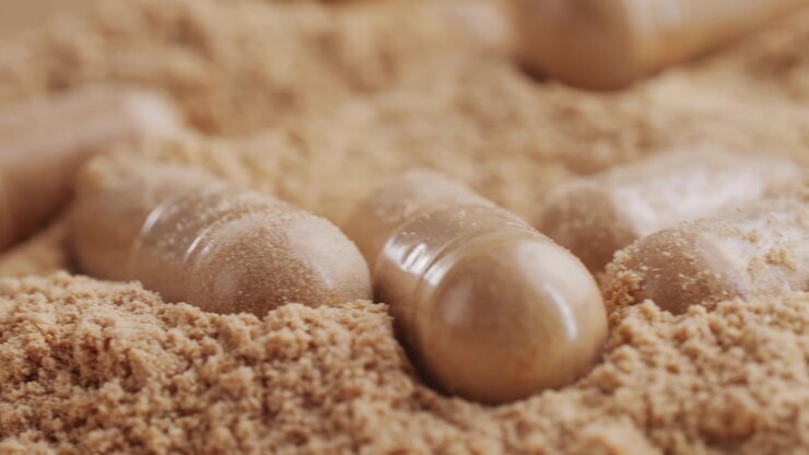 Medical Capsules Resting on a Bed of Brown Powder