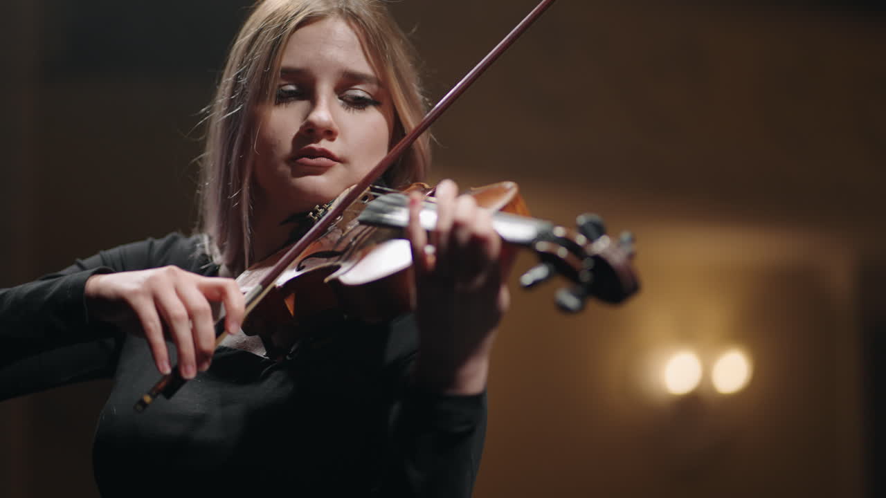 una mujer bonita está tocando el violín en la escena en el salón de música retrato de una mujer músico en la escena del salón de la música