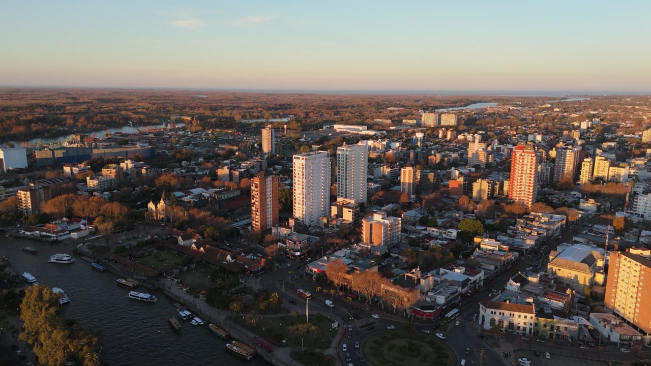 Veduta aerea del paesaggio urbano di Tigre con fiume e grattacieli al tramonto.