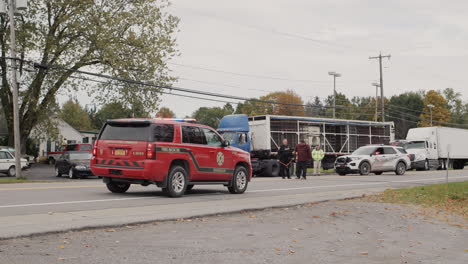 clarence, ny, usa, oktober 2021: der wind hat das stromkabel durchgeschnitten, es ist auf die straße gefallen. sheriff und assistenten regeln den verkehr, autos fahren um die klippe