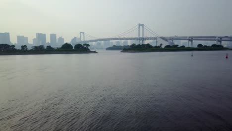 backwards close flying over water straight to rainbow bridge