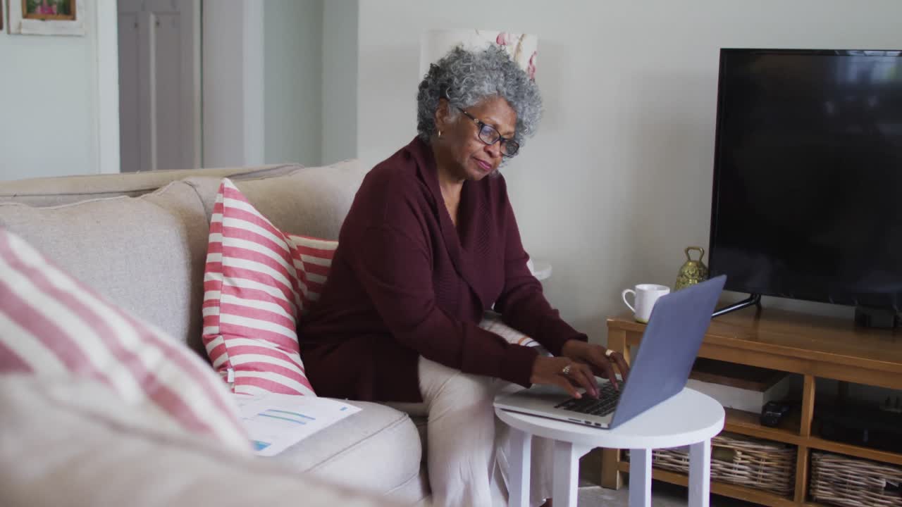 Senior african american female doctor having a video call on laptop at home