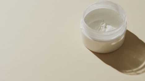 close up di una vasca di crema con spazio di copia su sfondo bianco