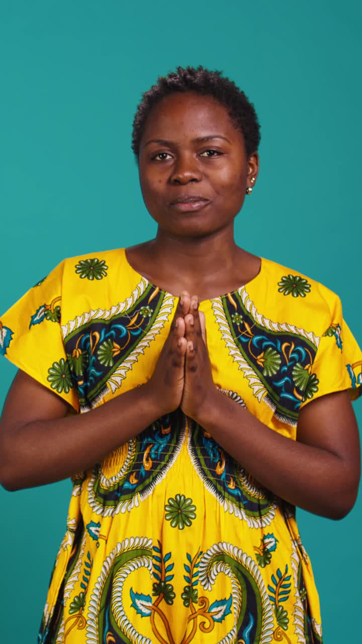African Woman in Yellow Dress Showing Namaste Gesture