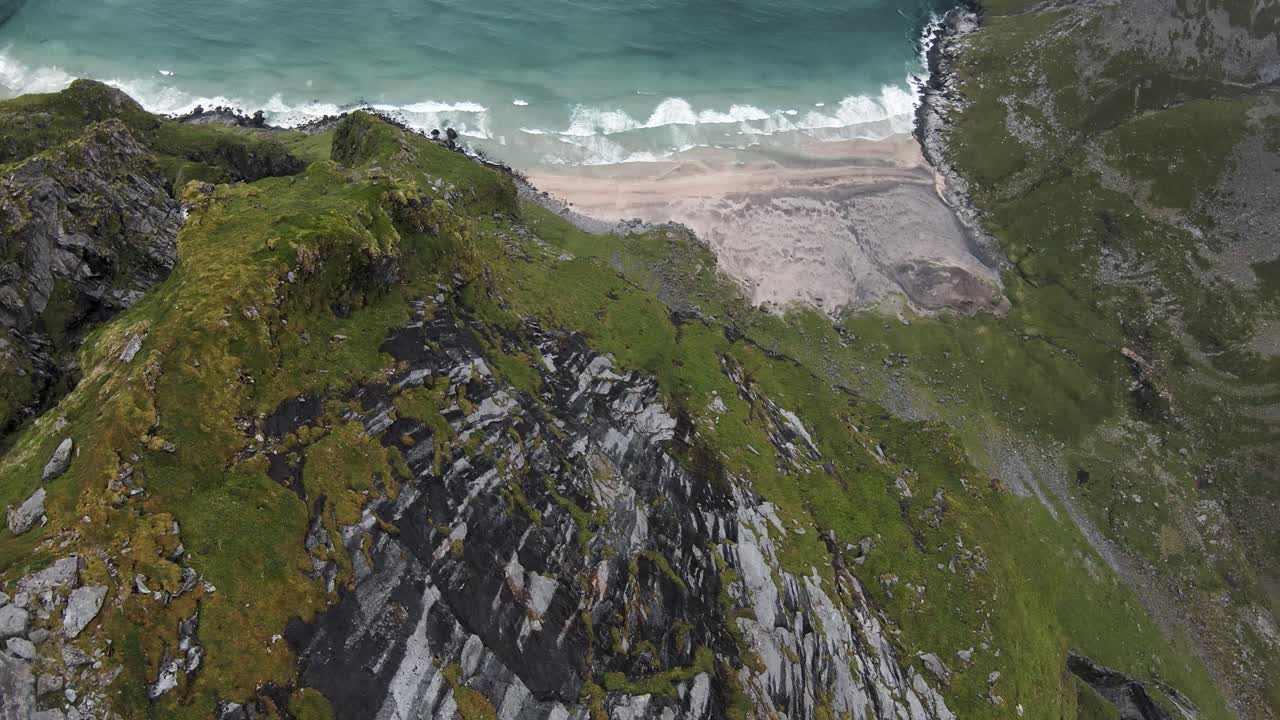 Tuffo dalla scogliera su una spiaggia che si affaccia sulla spiaggia e sull'oceano al rallentatore