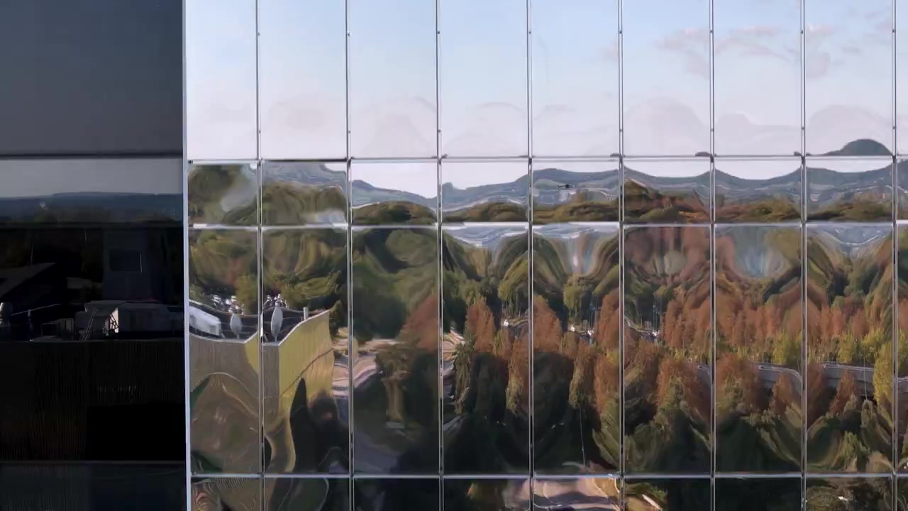 Aerial view descending modern mirrored glass hotel rooms on high rise building exterior