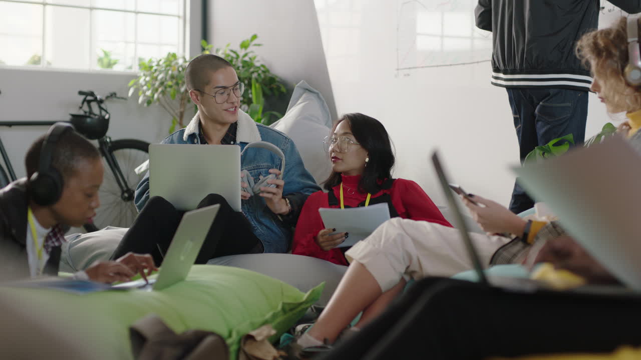 jóvenes empresarios creativos trabajando juntos amigos compartiendo auriculares escuchando música disfrutando de entretenimiento socializando en la oficina de moda workpalce