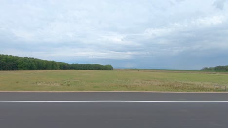 An-old-abandoned-barn-and-fields-lined-by-trees-in-this-drive-through-the-heartland-of-America