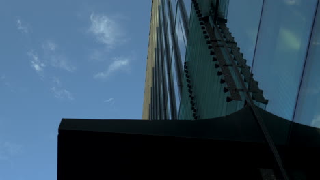 upward view of modern skyscraper with detailed facade against blue sky